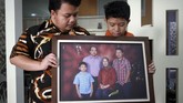 Muhammad Ivanka Rizaldi Nugroho (kiri) dan Muhammad Aufa Wikantyasa Nugroho (kanan). Dua putra mendiang Kepala Pusat Data Informasi dan Humas BNPB Sutopo Purwo Nugroho menunjukkan foto keluarga di rumah duka Raffles Hils, Cimanggis, Depok, Jawa Barat, Minggu (7/7). (ANTARA FOTO/Yulius Satria Wijaya)