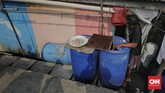 Warga memperbaiki instalasi penampungan air hujan miliknya di Kampung Nelayan Kamal Muara, Jakarta Utara, 9 Juli 2019. (CNN Indonesia/Adhi Wicaksono)