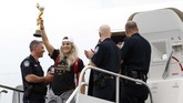 Julie Ertz mengangkat trofi Piala Dunia Wanita 2019 setelah ia keluar dari pesawat. (AP Photo/Kathy Willens)