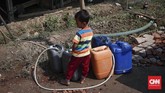 Seorang anak mengisi air ke dalam jeriken di Desa Ridomanah, Cibarusah, Jawa Barat, Rabu (10/7). (CNNIndonesia/Safir Makki)