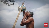 Warga membasuh muka dari air penampungan di Desa Sirna Jati, Cibarusah. Air ini hanya mereka gunakan untuk mencuci dan mandi. (CNNIndonesia/Safir Makki)