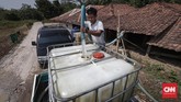 Warga menggunakan mobil mengisi air ke dalam tengki besar. Pompa dan selang besar diarahkan ke aliran sungai Cihoe, Desa Ridomanah. (CNNIndonesia/Safir Makki)