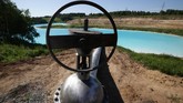 Pipa pembuangan limbah beracun di tepi danau. (Photo by Rostislav NETISOV / AFP)