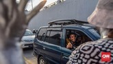 Merasa terhibur dengan aksi para manusia perak, seorang pengemudi tersenyum dan memberikan tanda apresiasi dalam bentuk uang. (CNN Indonesia/Daniela)