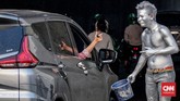 Seorang pengemudi terlihat memberikan tanda apresiasi dalam bentuk uang. (CNN Indonesia/Daniela)