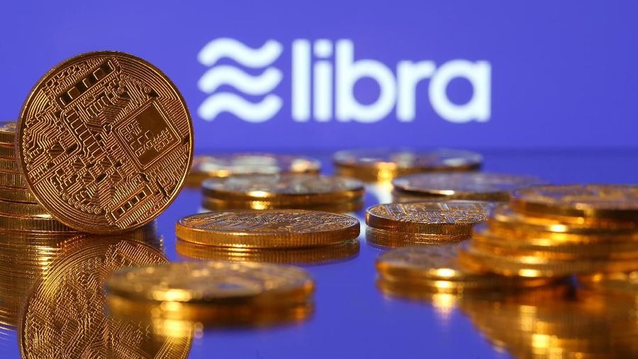FILE PHOTO: Small toy figures are seen on representations of virtual currency in front of the Libra logo in this illustration picture, June 21, 2019. REUTERS/Dado Ruvic/Illustration/File Photo