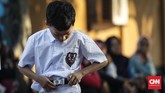 Siswa baru membenahi pakaian saat upacara bendera hari pertama masuk sekolah di SD Negeri Karet 01, Jakarta, 15 Juli 2019. (CNNIndonesia/Safir Makki)