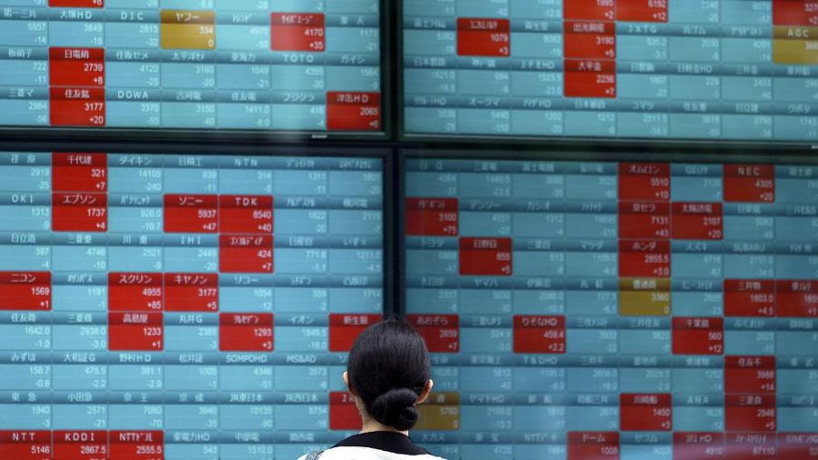 People walk past an electronic stock board showing Japan's Nikkei 225 index at a securities firm in Tokyo Wednesday, July 10, 2019. Asian shares were mostly higher Wednesday in cautious trading ahead of closely watched congressional testimony by the U.S. Federal Reserve chairman. (AP Photo/Eugene Hoshiko)