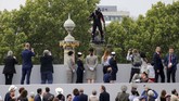 Ketika melihat papan terbang itu, para pengunjung bersorak dan berkeliling di atas Champs-Elysees ketika parade militer dilakukan (REUTERS/Pascal Rossignol)