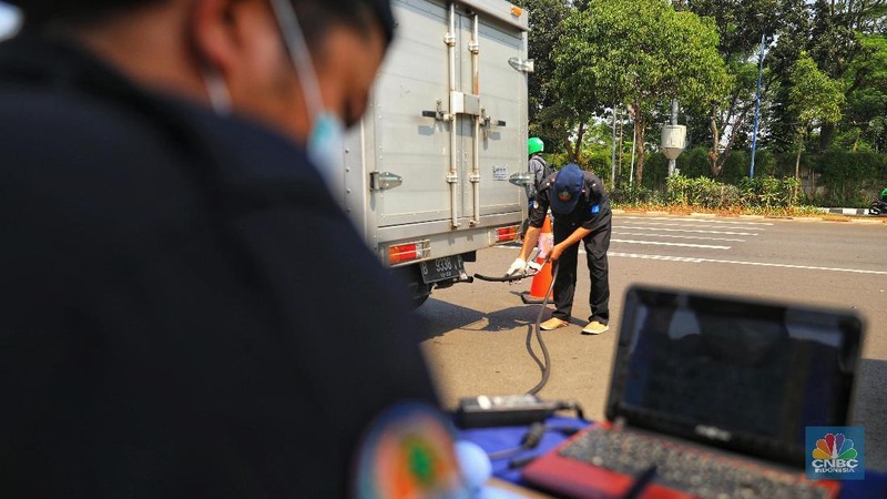 Petugas Suku Dinas Lingkungan Hidup melakukan uji emisi gas buangan kendaraan bermotor roda empat di Kawasan Senayan,  Selasa (16/7).