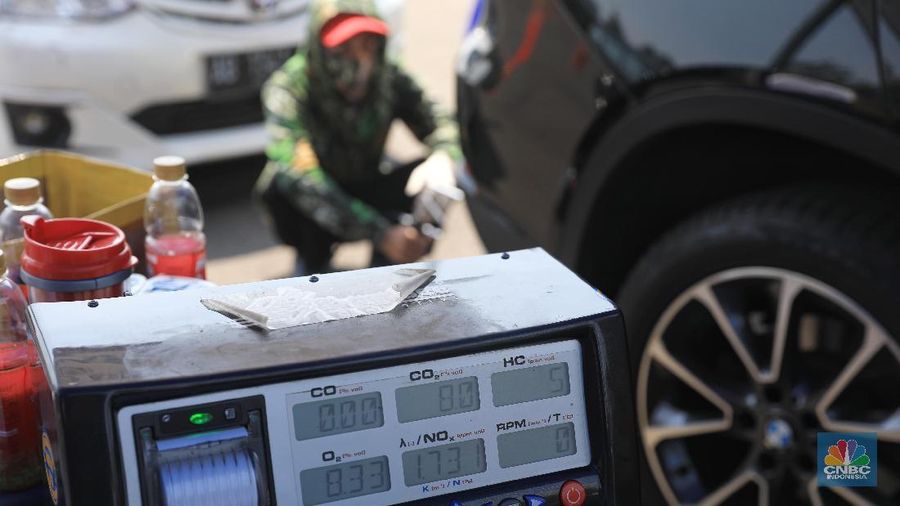 Petugas Suku Dinas Lingkungan Hidup melakukan uji emisi gas buangan kendaraan bermotor roda empat di Kawasan Senayan,  Selasa (16/7).