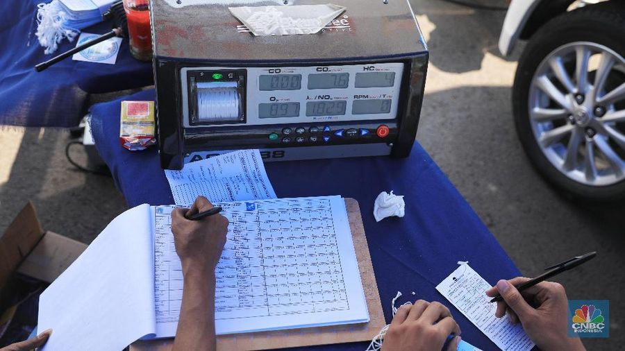 Petugas Suku Dinas Lingkungan Hidup melakukan uji emisi gas buangan kendaraan bermotor roda empat di Kawasan Senayan,  Selasa (16/7).