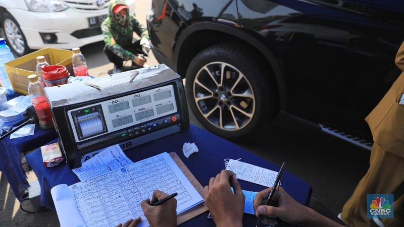 Petugas Suku Dinas Lingkungan Hidup melakukan uji emisi gas buangan kendaraan bermotor roda empat di Kawasan Senayan,  Selasa (16/7).