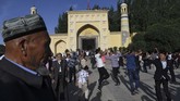 Pria-pria Uighur menari setelah salat Idulfiri di Masjid Id Kah, Kashgar. Pada tahun 2020, Xinjiang memiliki target 300 juta kunjungan wisatawan dan memperoleh pendapatan US$ 87 miliar. (GREG BAKER/AFP)