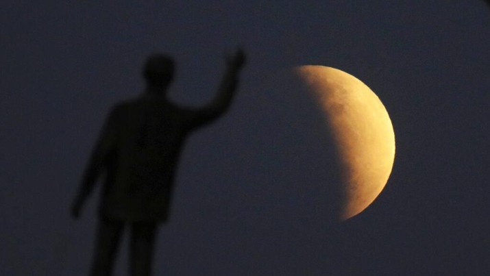 A statue of the Brazil's former President Juscelino Kubitschek, founder of Brasilia, stands during a partial lunar eclipse in the skies over Brasilia, Brazil, Tuesday, July 16, 2019. The partial lunar eclipse seen all over Brazil came the same day as the 50th anniversary of moon landings. (AP Photo/Eraldo Peres)