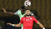 Gelandang Tunisia Ghailene Chaalali susah-payah duel udara dengan gelandang Nigeria Wilfred Ndidi. Ndidi masih tercatat sebagai pemain Leicster City. (REUTERS/Sumaya Hisham)