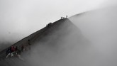 Masyarakat suku Tengger melintas di bibir kawah Gunung Bromo untuk melarung sesajen pada Upacara Yadnya Kasada, Probolinggo, Jawa Timur, Kamis (18/7). (ANTARA FOTO/Zabur Karuru)
