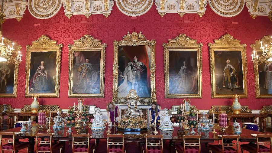 Employees pose as they view a dessert course menu setting on display in the State Dining Room as part of a special exhibition celebrating the 200th anniversary of the birth of Queen Victoria which marks this year's Summer Opening of Buckingham Palace in London, Britain, July 17, 2019. REUTERS/Toby Melville