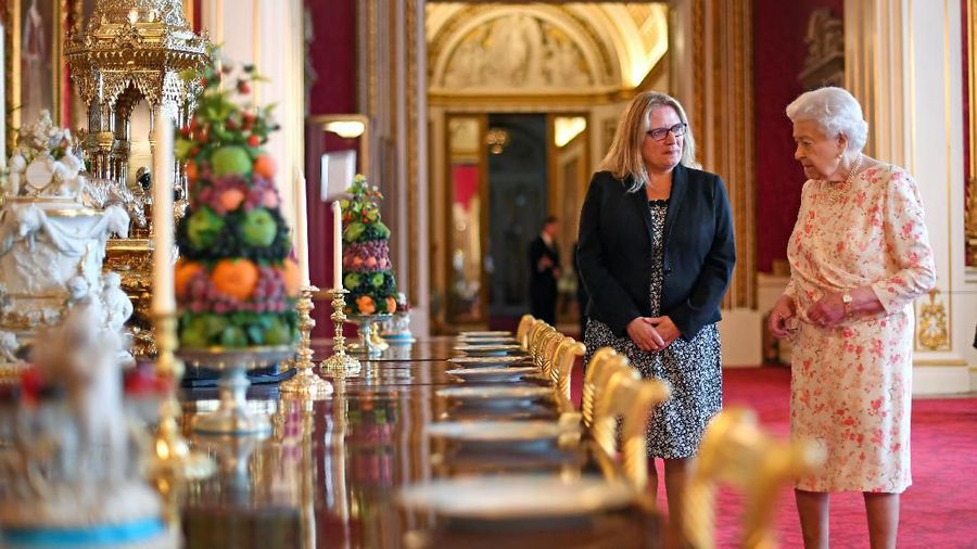 Britain's Queen Elizabeth II looks at a recreation of the 'Victoria' pattern dessert service in the State Dining Room, as part of the special exhibition celebrating the 200th anniversary of the birth of Queen Victoria which marks this year's Summer Opening of Buckingham Palace in London, Britain, July 17, 2019. Victoria Jones/Pool via REUTERS