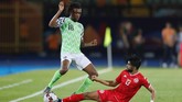 Gelandang Nigeria Alex Iwobi diadang pemain Tunisia Ferjani Sassi. Iwobi merupakan andalan di klub Liga Inggris Arsenal. (REUTERS/Mohamed Abd El Ghany)