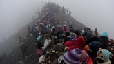 Masyarakat suku Tengger dan wisatawan berada di bibir kawah Gunung Bromo pada Upacara Yadnya Kasada, Probolinggo, Jawa Timur, Kamis (18/7). (ANTARA FOTO/Zabur Karuru)