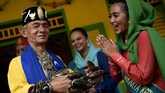Seorang perwakilan Abang None menyambut pengunjung dengan mengenakan pakaian adat Betawi saat Lebaran Betawi 2019 di lapangan silang Monumen Nasional. (ANTARA FOTO/M Risyal Hidayat)