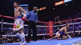 Manny Pacquiao berjalan menjauhi Keith Thurman setelah berhasil membuat petinju Amerika Serikat itu roboh di ronde pertama. (REUTERS/Joe Camporeale-USA TODAY Sports)