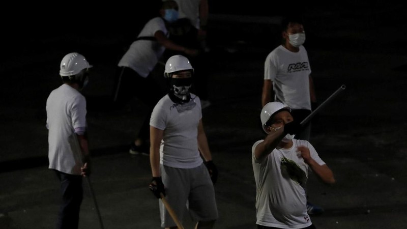 Sekelompok orang tak dikenal berbaju putih bersenjatakan tongkat kayu dan besi menyerang massa pengunjuk rasa yang berpakaian hitam