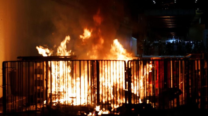 Sebuah barikade terbakar saat bentrokan antara pendemo anto ekstradisi dengan polisi anti huru hara di Hong Kong, Cina (21/7/2019). (REUTERS / Tyrone Siu) A barricade burns as riot police stand guard, after a march to call for democratic reforms in Hong Kong, China July 21, 2019. REUTERS/Tyrone Siu