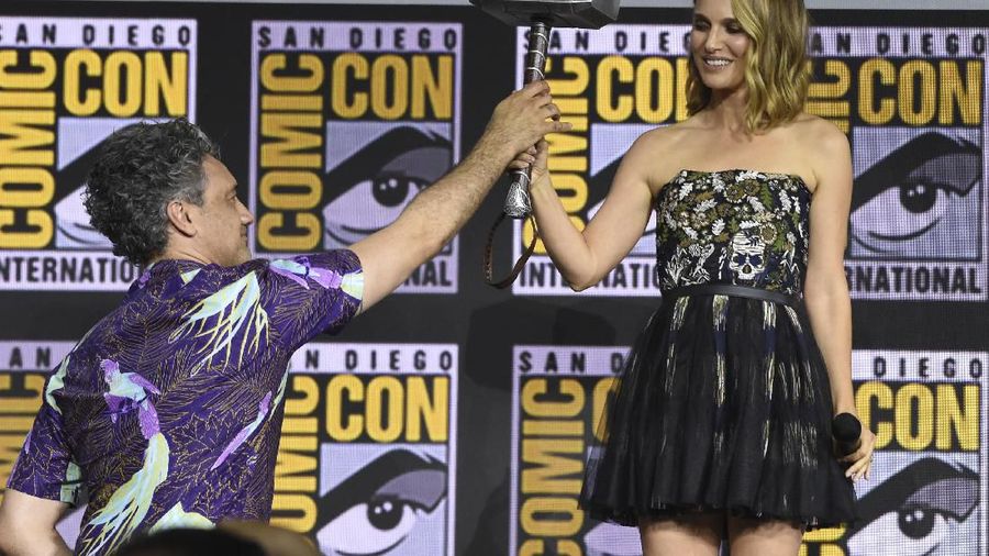 Director Taika Waititi hands the Thor hammer to Natalie Portman during the 