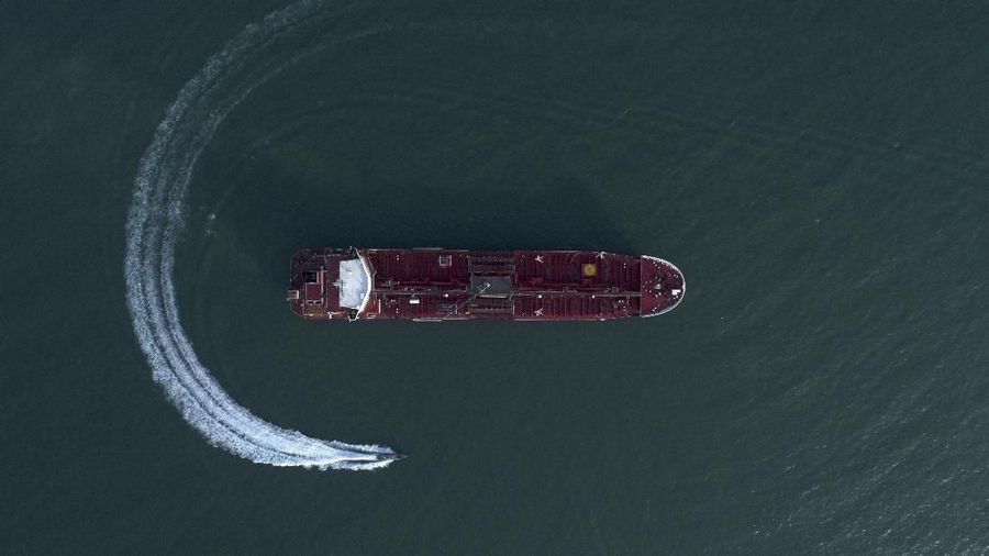 In this Sunday, July 21, 2019 photo, an aerial view shows a speedboat of Iran's Revolutionary Guard moving around the British-flagged oil tanker Stena Impero which was seized in the Strait of Hormuz on Friday by the Guard, in the Iranian port of Bandar Abbas. Global stock markets were subdued Monday while the price of oil climbed as tensions in the Persian Gulf escalated after Iran's seizure of a British oil tanker on Friday. (Morteza Akhoondi/Tasnim News Agency via AP)