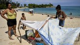 Pemandangan liburan keluarga di Pantai Bacuranao. Pemerintah Kuba menjamin akses ke pantai-pantai bagi para penduduknya, namun nyatanya tidak semua penduduk dapat menikmati pantai berpasir putih dan berair biru jernih di sana. (AFP/Yamil Lage)