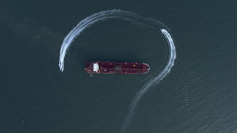 In this Sunday, July 21, 2019 photo, an aerial view shows a speedboat of Iran's Revolutionary Guard moving around the British-flagged oil tanker Stena Impero which was seized in the Strait of Hormuz on Friday by the Guard, in the Iranian port of Bandar Abbas. Global stock markets were subdued Monday while the price of oil climbed as tensions in the Persian Gulf escalated after Iran's seizure of a British oil tanker on Friday. (Morteza Akhoondi/Tasnim News Agency via AP)