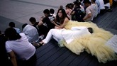 Pasangan kekasih beristirahat di anak tangga di sela-sela sesi pemotretat pernikahan mereka di Bund, Shanghai, China. (Reuters/Aly Song)