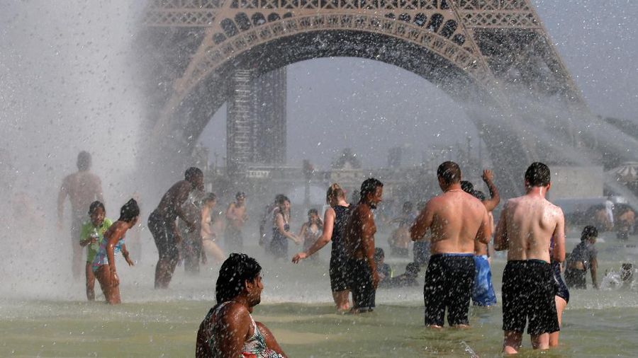 People cool off in the Trocadero fountains across from the Eiffel Tower in Paris as a new heatwave broke temperature records in France, July 25, 2019. REUTERS/Pascal Rossignol