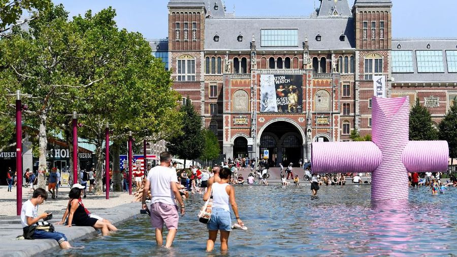 REFILE - ADDING COUNTRY People cool off during a sunny day at a pond in front of the Rijksmuseum in Amsterdam, the Netherlands, July 25, 2019. REUTERS/Piroschka van de Wouw