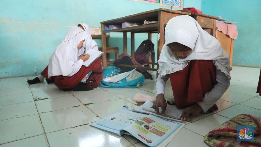 Akibat kekurangan bangku sejumlah siswa terpaksa disekolah tersebut harus duduk satu meja untuk tiga orang.