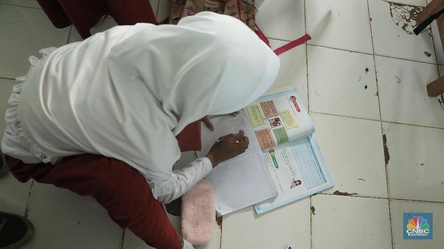 Akibat kekurangan bangku sejumlah siswa terpaksa disekolah tersebut harus duduk satu meja untuk tiga orang.