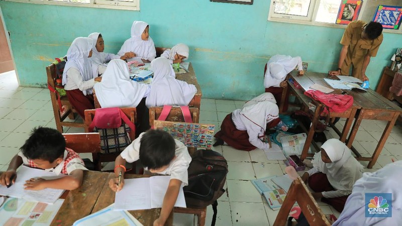 Akibat kekurangan bangku sejumlah siswa terpaksa disekolah tersebut harus duduk satu meja untuk tiga orang.