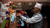 Ghantakarna digambarkan memiliki tubuh yang dicat warna merah, biru, dan hitam. Ia juga mengenakan sepasang lonceng di telinga. (REUTERS/Navesh Chitrakar)