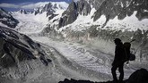 Seorang pria berdiri di atas gletser Mer de Glace di Chamonix, Rabu (19/6). (AFP/Marco Bertorello).
