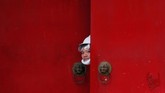 Seorang pria berbaju putih mengintip dari pintu masuk Desa Nam Pin Wai saat protes dilakukan terhadap aksi Yuen Long di Yuen Long, Hong Kong, Sabtu (27/7). (Reuters/Tyrone Siu).