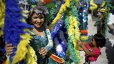 Seorang gadis bermain dengan kostum pemain sebelum parade pembukaan perayaan El Divino Salvador del Mundo. (REUTERS/Jose Cabezas)