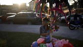 Maria de Jesus Guzman menjual mainan sebelum parade pembukaan perayaan El Divino Salvador del Mundo, 1 Agustus 2019. (REUTERS/Jose Cabezas)