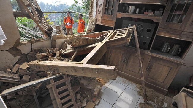 Relawan memeriksa rumah warga yang rusak akibat diguncang gempa di Kampung Karoya, Mandalawangi, Pandeglang, Banten, Sabtu (3/8/2019). Menurut data BPBD Banten dua orang meninggal dan sebanyak 112 rumah rusak berat dan ringan. (ANTARA FOTO/Asep Fathulrahman/ama)