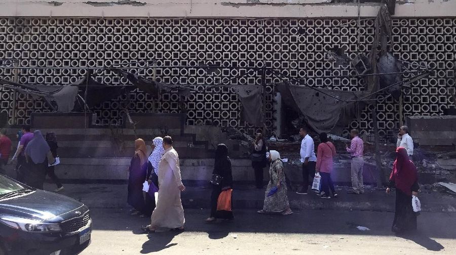 People survey the aftermath of a fiery car crash outside the National Cancer Institute in Cairo, Egypt, Monday, Aug. 5, 2019. The multiple-car crash set off an explosion that ignited a fire at Egypt's main cancer hospital, the government said.(AP Photo/Maya Alleruzzo)