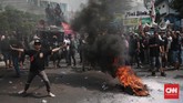 Aksi demonstrasi berakhir ricuh, massa melakukan aksi bakar atribut jaket Gojek. (CNN Indonesia/Andry Novelino)