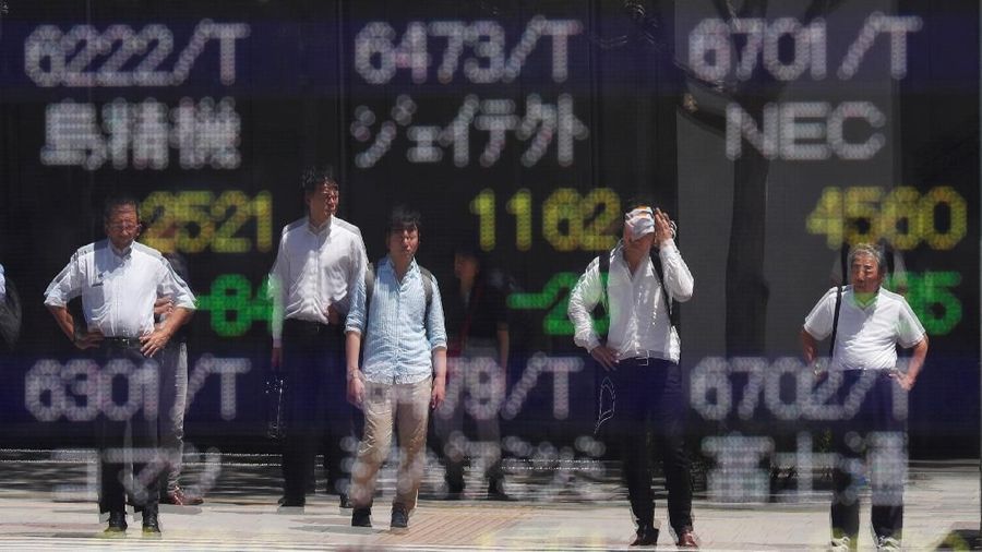 Passersby are reflected on an electronic board showing the exchange rates between the Japanese yen and the U.S. dollar, the yen against the euro, the yen against the Australian dollar, Dow Jones Industrial Average and other market indices outside a brokerage in Tokyo, Japan, August 6, 2019.   REUTERS/Issei Kato