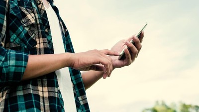 Close-up of hipster man hands using his smartphone outdoor in the park.