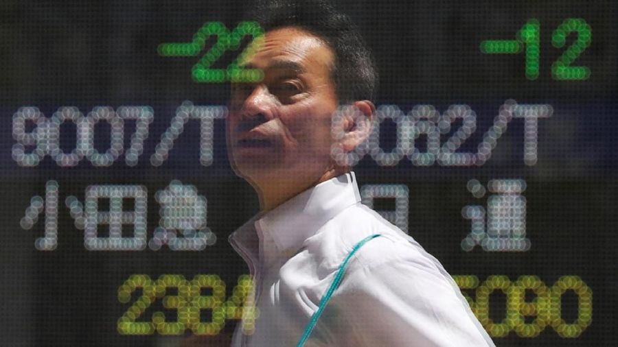 Passersby are reflected on an electronic board showing the exchange rates between the Japanese yen and the U.S. dollar, the yen against the euro, the yen against the Australian dollar, Dow Jones Industrial Average and other market indices outside a brokerage in Tokyo, Japan, August 6, 2019.   REUTERS/Issei Kato